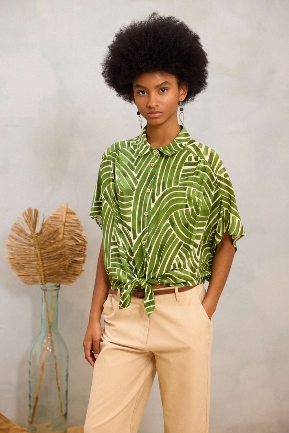 "DARYA" πουκάμισο Namaste Cropped πουκάμισο από δροσερό 100% rayon, με γιακά και κλείσιμο μπροστά που καταλήγει σε ιδιαίτερο δέσιμο στο τελείωμα. Διαθέτει κοντά μανίκια που πέφτουν μαλακά στους ώμους και δημιουργούν ελαφριά σούρα στο μπροστινό μέρος. Στο πίσω μέρος εχει ωμίτη με πιέτες στο κέντρο και λάστιχο στο κάτω μέρος που εξασφαλίζει άψογη εφαρμογή. Το ιδιαίτερο γεωμετρικό print με αφαιρετικές γραμμές ολοκληρώνει το σχέδιο με σύγχρονο, δυναμικό χαρακτήρα. Σύνθεση : 100% Ρεγιόν Τα ρούχα Namaste σχεδιάζονται και ράβονται στην Ελλάδα. Δωρεάν αποστολή σε 1-3 μέρες σε όλη την Ελλάδα. Διαθέσιμο και στο φυσικό κατάστημα YELLOW BUTTON Χρεμωνίδου & Δαμάρεως 61 Παγκράτι