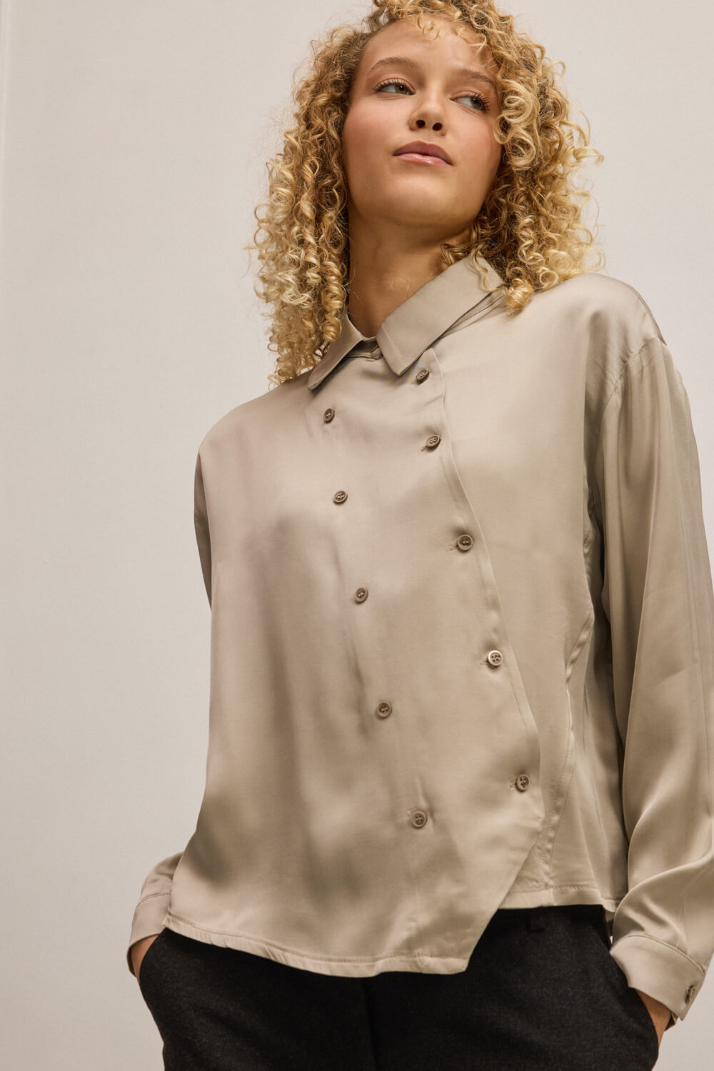 "GRINI" πουκάμισο με μεταξένια υφή Namaste Πουκάμισο με μεταξένια υφή και διακριτική λάμψη, που ξεχωρίζει για την ιδιαίτερη κατασκευή του. Το ασύμμετρο μπροστινό κλείσιμο με διπλή σειρά κουμπιών δημιουργεί σχεδιαστικό στίγμα, τονίζοντας τον αρχιτεκτονικό χαρακτήρα του σχεδίου. Ο κλασικός γιακάς ισορροπεί αρμονικά με τον σχεδιαστικό δυναμισμό ενώ τα μακριά μανίκια καταλήγουν σε μανσέτα με κουμπί προσφέροντας σταθερότητα και άψογο φινίρισμα. “Αυτό το προϊόν έχει φτιαχτεί με αγάπη και σεβασμό στο περιβάλλον χρησιμοποιώντας φυσικές ίνες.” 52% Ecovero Βισκόζη 48% Ρεγιόν Τα ρούχα Namaste σχεδιάζονται και ράβονται στην Ελλάδα. Δωρεάν αποστολή σε 1-3 μέρες σε όλη την Ελλάδα. Διαθέσιμο και στα φυσικά καταστήματα YELLOW BUTTON Χρεμωνίδου & Δαμάρεως 61 Παγκράτι Γρ. Αυξεντίου 122 Ιλίσια