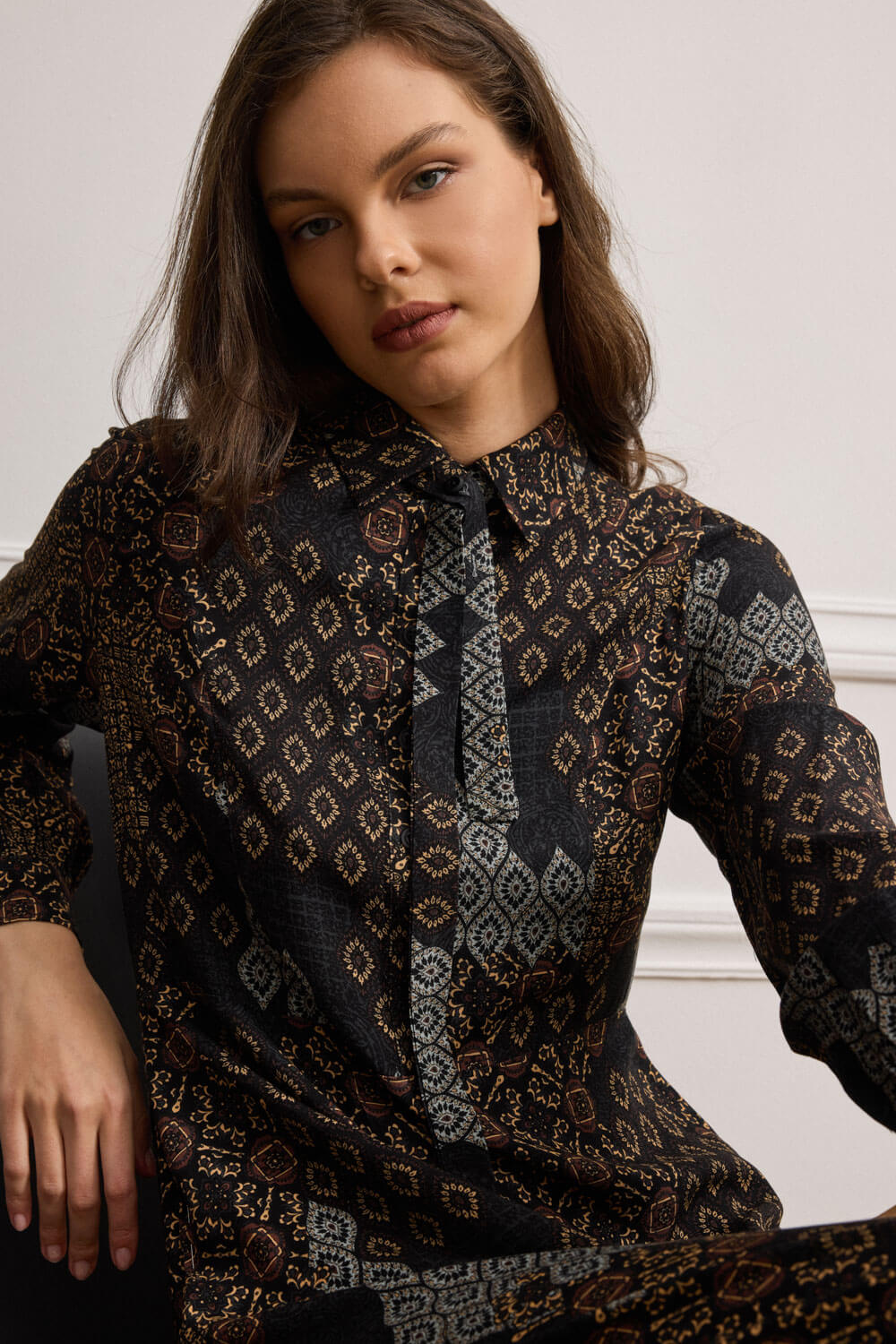 "CLEO" μακρύ φόρεμα Namaste Μακρύ φόρεμα με ethnic μοτίβο δημιουργεί δυναμική εικόνα και ξεχωριστές λεπτομέρειες, σε ίσια γραμμή που αναδεικνύει τη σιλουέτα με διακριτική κομψότητα. Κατασκευασμένο από 100% viscose, προσφέρει απαλή υφή, ενώ ο γιακάς τύπου πουκαμίσου και η πατιλέτα μπροστά με κουμπιά τονίζουν τη δομημένη αισθητική του φορέματος. Τα μακριά μανίκια καταλήγουν σε μανσέτες που κλείνουν με κουμπί και έχει πλαϊνά ανοίγματα στο τελείωμα. Ιδιαίτερη σχεδιαστική λεπτομέρεια, η αποσπώμενη “γραβάτα” από το ίδιο ύφασμα που δένει στον λαιμό και στερεώνεται με κουμπί, προσθέτοντας μοντέρνο twist στην κλασική γραμμή. “Αυτό το προϊόν έχει φτιαχτεί με αγάπη και σεβασμό στο περιβάλλον χρησιμοποιώντας φυσικές ίνες.” 100% Βισκόζη Τα ρούχα Namaste σχεδιάζονται και ράβονται στην Ελλάδα. Δωρεάν αποστολή σε 1-3 μέρες σε όλη την Ελλάδα. Διαθέσιμο και στο φυσικό κατάστημα YELLOW BUTTON Χρεμωνίδου & Δαμάρεως 61 Παγκράτι