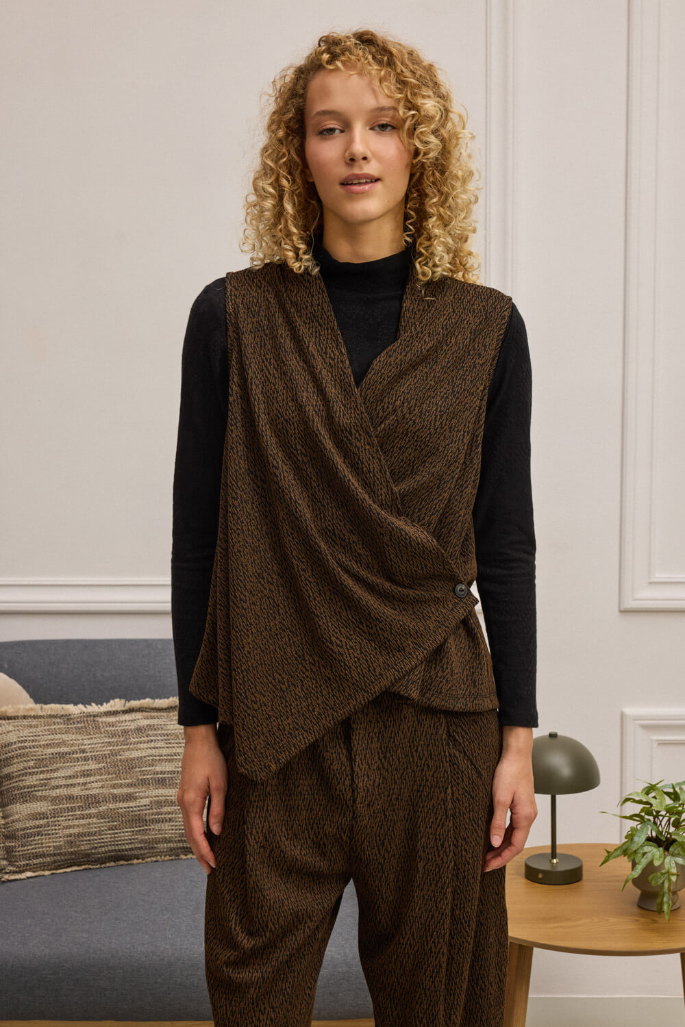 "ACHARA" γιλέκο κρουαζέ Namaste Αμάνικο γιλέκο με κρουαζέ κόψιμο και περίτεχνη ασυμμετρία στο μπροστινό μέρος που σχηματίζει διακριτική μύτη. Κατασκευασμένο από ελαστικό ανάγλυφo ύφασμα που χαρίζει υφή και άνεση. Δένει εσωτερικά με κορδόνι και εξωτερικά με κουμπί, προσφέροντας σταθερότητα και σχεδιαστική ισορροπία. Συνδυάζεται ιδανικά με το παντελόνι ADRITTI για ένα ολοκληρωμένο look με χαρακτήρα. 71% Πολυέστερ 25% Βισκόζη 4% Ελαστάν Τα ρούχα Namaste σχεδιάζονται και ράβονται στην Ελλάδα. Δωρεάν αποστολή σε 1-3 μέρες σε όλη την Ελλάδα. Διαθέσιμο και στο φυσικό κατάστημα YELLOW BUTTON Χρεμωνίδου & Δαμάρεως 61 Παγκράτι