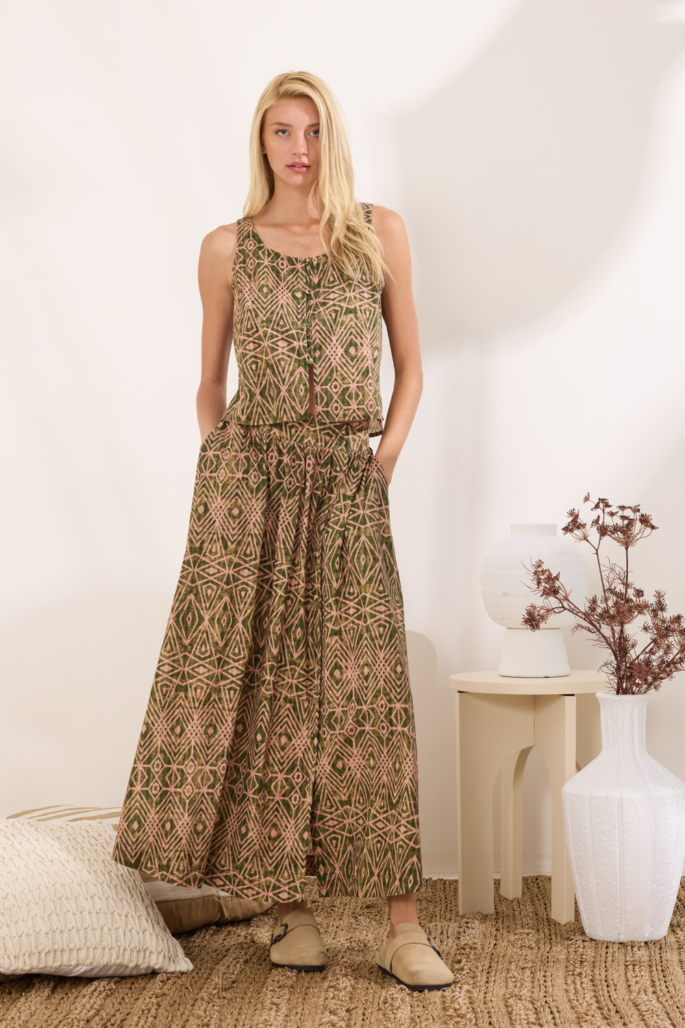 "MINGUS" φούστα maxi Namaste Φούστα maxi από 100% βαμβάκι, με ανάλαφρη υφή και φυσική αίσθηση. Το επάνω μέρος διαθέτει σούρες που δίνουν όγκο και κίνηση. Διαθέτει άνοιγμα στο πλάι σε όλο το μήκος που κλείνει με κουμπιά καλυμμένα από το ίδιο ύφασμα. Περιλαμβάνει πλαϊνές τσέπες για πρακτικότητα, ενώ το μοτίβο κινείται σε african watercolour ύφος, με γεωμετρικά στοιχεία. Συνδυάζεται με το τοπ EVANSY_1 για ένα ολοκληρωμένο σετ. “Αυτό το προϊόν έχει φτιαχτεί με αγάπη και σεβασμό στο περιβάλλον χρησιμοποιώντας φυσικές ίνες" 100% Βαμβάκι Το μοντέλο φοράει μέγεθος S. Τα ρούχα Namaste σχεδιάζονται και ράβονται στην Ελλάδα. Δωρεάν αποστολή σε 1-3 μέρες σε όλη την Ελλάδα. Διαθέσιμο και στο φυσικό κατάστημα YELLOW BUTTON Χρεμωνίδου & Δαμάρεως 61 Παγκράτι