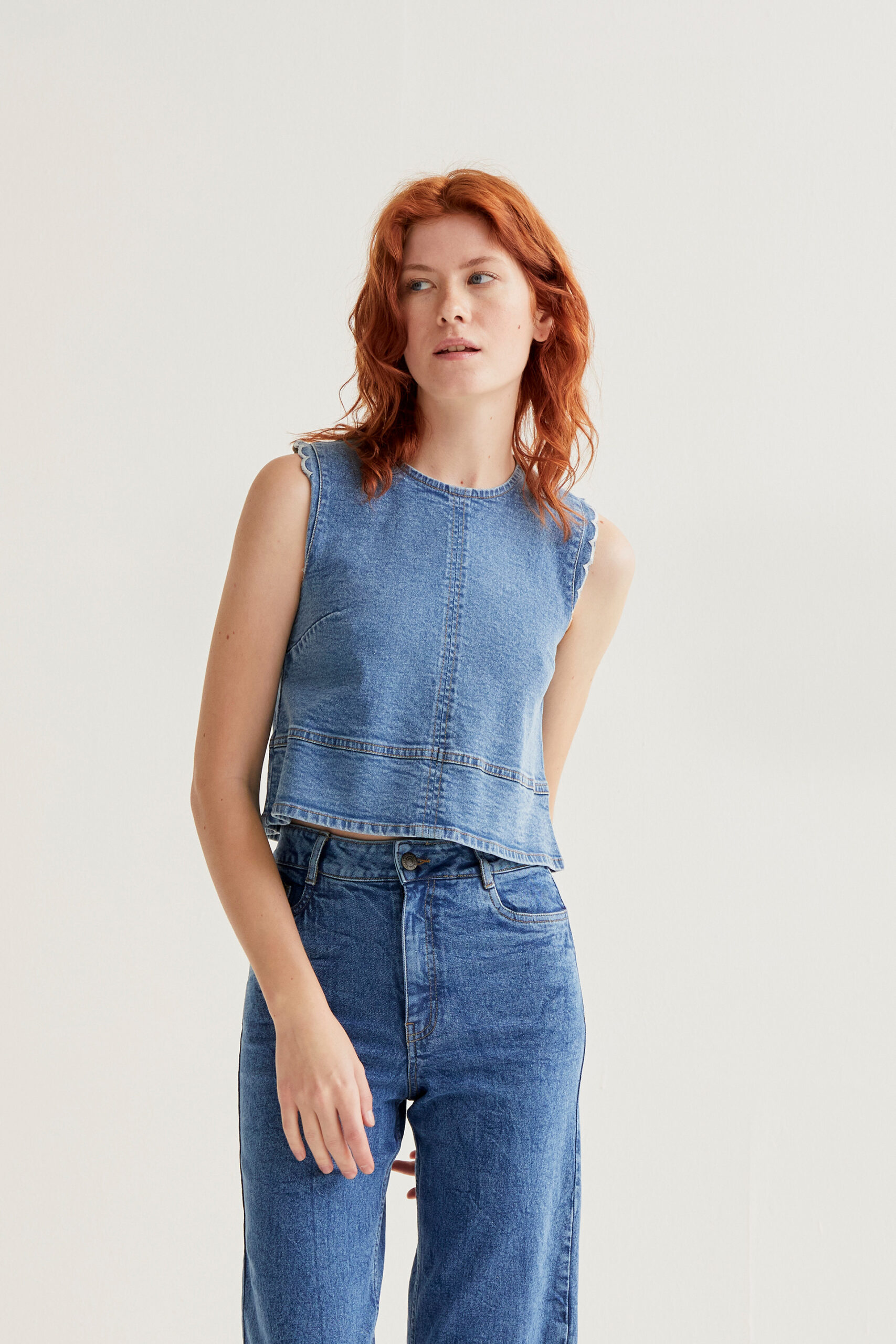 Μπλε τζιν τοπ. Στρογγυλή λαιμόκοψη και αμάνικο. Κλείσιμο με κουμπιά στο πίσω μέρος. Λευκή κυματιστή λεπτομέρεια. Το μοντέλο έχει ύψος 175 εκ. και φοράει μέγεθος S. Πλένεται στο πλυντήριο με κρύο νερό, όχι στεγνωτήριο, στέγνωμα στην σκιά, σιδερώνεται σε μέγιστη θερμοκρασία 110°C 98% Cotton 2% Elastane Αποστολή σε όλη την Ελλάδα σε 1-3 ημέρες. Διαθέσιμο και στα φυσικά μας κατάστηματα YELLOW BUTTON                                        Χρεμωνίδου & Δαμάρεως 61 Παγκράτι. Γρηγορίου Αυξεντίου 122 Άνω Ιλίσια Βάλτε τον κωδικό COMPANIA στο κουπόνι και κερδίστε 10% έκπτωση!