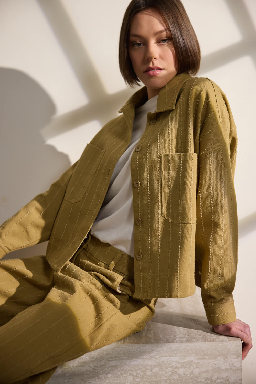 Jacket από 100% βαμβάκι, κατασκευασμένο από ιδιαίτερο ριγέ ύφασμα με διακριτικά ξέφτια που προσθέτουν υφή και χαρακτήρα. Διαθέτει γιακά και κλείνει με κουμπιά σε όλο το μπροστινό μέρος, ενώ τα μακριά μανίκια ολοκληρώνονται με κουμπί στο τελείωμα. Διαθέτει μικρά ανοίγματα στα πλαϊνά και δύο μεγάλες μπροστινές τσέπες. Η κοντή, ελαφρώς boxy γραμμή του δημιουργεί ένα μοντέρνο και ισορροπημένο αποτέλεσμα. “Αυτό το προϊόν έχει φτιαχτεί με αγάπη και σεβασμό στο περιβάλλον χρησιμοποιώντας φυσικές ίνες.” 100% Βαμβάκι Τα ρούχα Namaste σχεδιάζονται και ράβονται στην Ελλάδα. Δωρεάν αποστολή σε 1-3 μέρες σε όλη την Ελλάδα. Διαθέσιμο και στο φυσικό κατάστημα YELLOW BUTTON Χρεμωνίδου & Δαμάρεως 61 Παγκράτι