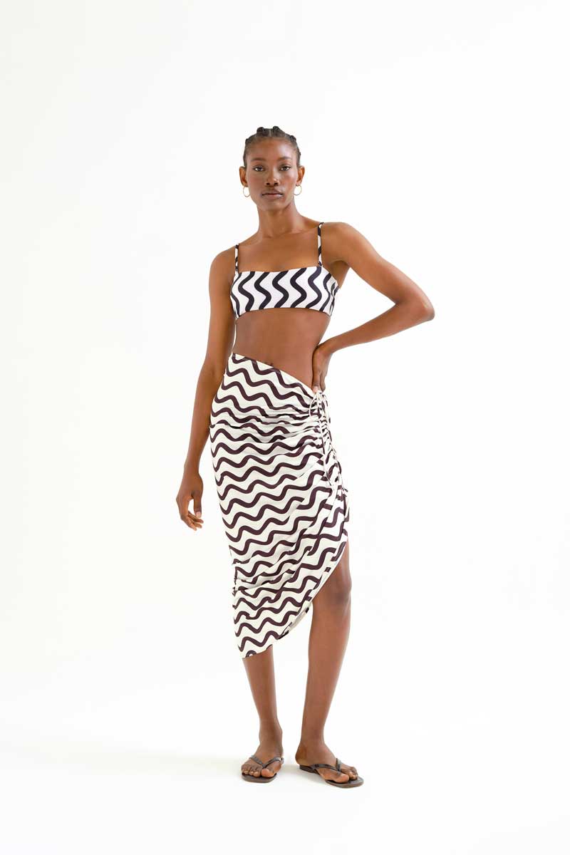 Φούστα παρεό με ασπρόμαυρο Wave print. Σχέδιο με κορδόνι και λάστιχο στο πλάι για να διαμορφώσετε το σχέδιο της και το μήκος της. Ύφασμα όπως η υφή του μαγιό. Στεγνώνει πολύ γρήγορα. Ελαστική μέση. 95% Πολυέστερ 5% Ελαστάν Το μοντέλο έχει ύψος 177 εκ. και φοράει μέγεθος S. Πλένεται στο πλυντήριο με κρύο νερό, όχι στεγνωτήριο, στέγνωμα στην σκιά, σιδερώνεται σε μέγιστη θερμοκρασία 110°C Αποστολή σε όλη την Ελλάδα σε 1-3 ημέρες. Διαθέσιμο και στα φυσικά μας κατάστηματα YELLOW BUTTON                                        Χρεμωνίδου & Δαμάρεως 61 Παγκράτι. Γρηγορίου Αυξεντίου 122 Άνω Ιλίσια Βάλτε τον κωδικό COMPANIA στο κουπόνι και κερδίστε 10% έκπτωση!