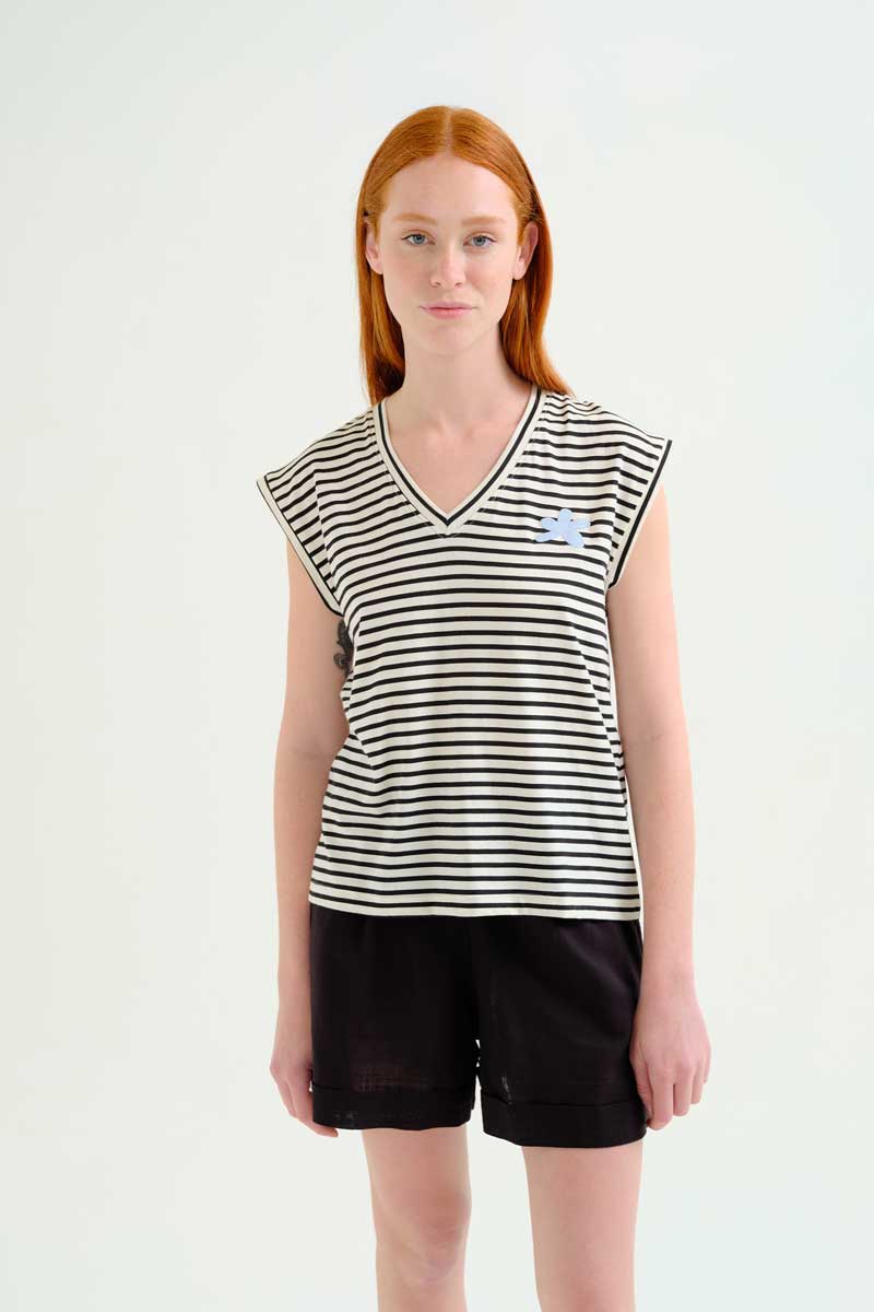 Μπλούζα από 100% βαμβάκι με ρίγες σε λευκό και μαύρο χρώμα. V ντεκολτέ και κοντά μανίκια. Κεντημένη μπλε λεπτομέρεια με λουλούδι. 100% Βαμβάκι Το μοντέλο έχει ύψος 175 εκ. και φοράει μέγεθος S. Πλένεται στο πλυντήριο με κρύο νερό, όχι στεγνωτήριο, στέγνωμα στην σκιά, σιδερώνεται σε μέγιστη θερμοκρασία 110°C Αποστολή σε όλη την Ελλάδα σε 1-3 ημέρες. Διαθέσιμο και στα φυσικά μας κατάστηματα YELLOW BUTTON Χρεμωνίδου & Δαμάρεως 61 Παγκράτι. Γρηγορίου Αυξεντίου 122 Άνω Ιλίσια Βάλτε τον κωδικό COMPANIA στο κουπόνι και κερδίστε 10% έκπτωση!