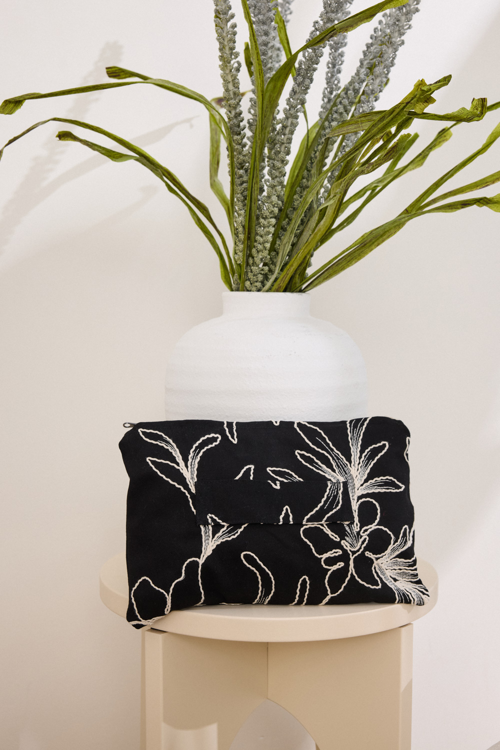 Τσάντα χειρός μικρού μεγέθους από 100% βαμβάκι με κεντημένα λουλούδια σε έντονη αντίθεση. Κλείνει με φερμουάρ στο επάνω μέρος και διαθέτει φαρδύ θύλακι στο κέντρο που περνά εύκολα στον καρπό για άνετο κράτημα. Το εσωτερικό της είναι ενιαίο, προσφέροντας πρακτικό χώρο για τα απαραίτητα αντικείμενα. “Αυτό το προϊόν έχει φτιαχτεί με αγάπη και σεβασμό στο περιβάλλον χρησιμοποιώντας φυσικές ίνες.” Διαθέσιμη και στο φυσικό κατάστημα YELLOW BUTTON Χρεμωνίδου & Δαμάρεως 61 Παγκράτι Γρ. Αυξεντίου 122 Ιλίσια