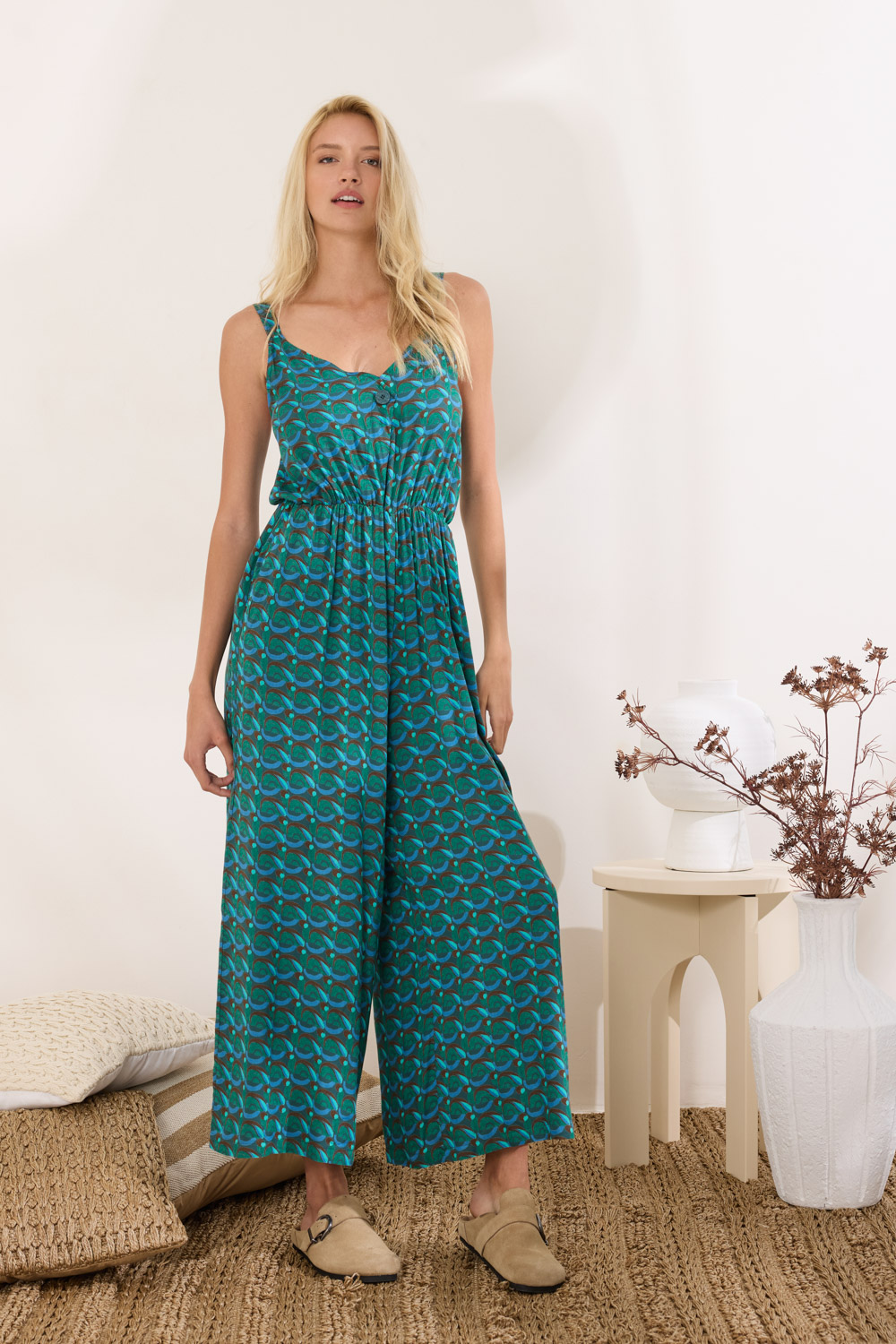 Ολόσωμη φόρμα από δροσερή viscose με ιδιαίτερο print που ξεχωρίζει. Η V λαιμόκοψη πλαισιώνεται από σχεδιαστικό κλείσιμο με κουμπί στο ντεκολτέ, προσθέτοντας ένα διακριτικό twist. Διαθέτει ρυθμιζόμενες τιράντες, κοφτές μπροστινές τσέπες και αόρατο φερμουάρ στο πλάι για άψογη εφαρμογή. Η χαμηλοκάβαλη γραμμή της και το διακριτικό λάστιχο στη μέση αναδεικνύει τη σιλουέτα και τονίζει τη χαλαρή, αλλά προσεγμένη αισθητική του κομματιού. “Αυτό το προϊόν έχει φτιαχτεί με αγάπη και σεβασμό στο περιβάλλον χρησιμοποιώντας φυσικές ίνες 100% Βισκόζη Το μοντέλο φοράει μέγεθος S. Τα ρούχα Namaste σχεδιάζονται και ράβονται στην Ελλάδα. Δωρεάν αποστολή σε 1-3 μέρες σε όλη την Ελλάδα. Διαθέσιμο και στο φυσικό κατάστημα YELLOW BUTTON Χρεμωνίδου & Δαμάρεως 61 Παγκράτι