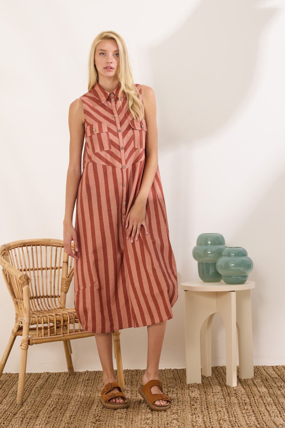 Φόρεμα midi αμάνικο με γιακά, από 100% cotton. Στο επάνω μέρος ξεχωρίζει το chevron μοτίβο, ενώ το υπόλοιπο έχει κάθετη ρίγα. Κλείνει μπροστά σε όλο το μήκος με κουμπιά και διαθέτει σχεδιαστικές ραφές και τσέπες με καπάκι που προσθέτουν κομψές λεπτομέρειες. Η ιδιαίτερη κατασκευή στη γραμμή δημιουργεί ένα διακριτικό balloon εφέ, χαρίζοντας σύγχρονη αισθητική και μοναδικό χαρακτήρα στο σχέδιο. “Αυτό το προϊόν έχει φτιαχτεί με αγάπη και σεβασμό στο περιβάλλον χρησιμοποιώντας φυσικές ίνες.” 100% Βαμβάκι Το μοντέλο φοράει μέγεθος S. Τα ρούχα Namaste σχεδιάζονται και ράβονται στην Ελλάδα. Δωρεάν αποστολή σε 1-3 μέρες σε όλη την Ελλάδα. Διαθέσιμο και στο φυσικό κατάστημα YELLOW BUTTON Χρεμωνίδου & Δαμάρεως 61 Παγκράτι