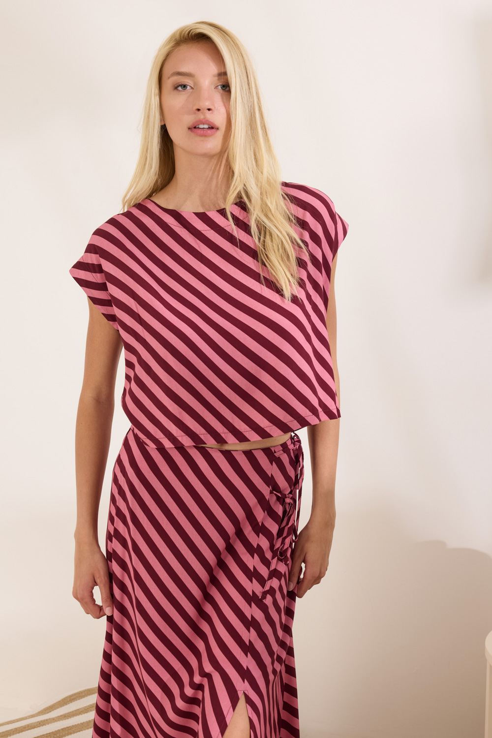 Τουνίκ με κοντό μανίκι και ανοιχτή λαιμόκοψη, σε cropped μήκος με χαλαρή και άνετη γραμμή. Διακοσμείται με έντονο print με ρίγες σε χρωματικό συνδυασμό σε αντίθεση, προσδίδοντας μοντέρνο και ζωντανό ύφος. Το πίσω μέρος είναι σχεδιαστικό και κλείνει με κουμπιά σε όλο το μήκος. Ιδανικό για να φορεθεί σαν σετ με τη φούστα Kathy για ολοκληρωμένο look. 100% Ρεγιόν Το μοντέλο φοράει μέγεθος S. Τα ρούχα Namaste σχεδιάζονται και ράβονται στην Ελλάδα. Δωρεάν αποστολή σε 1-3 μέρες σε όλη την Ελλάδα. Διαθέσιμο και στο φυσικό κατάστημα YELLOW BUTTON Χρεμωνίδου & Δαμάρεως 61 Παγκράτι