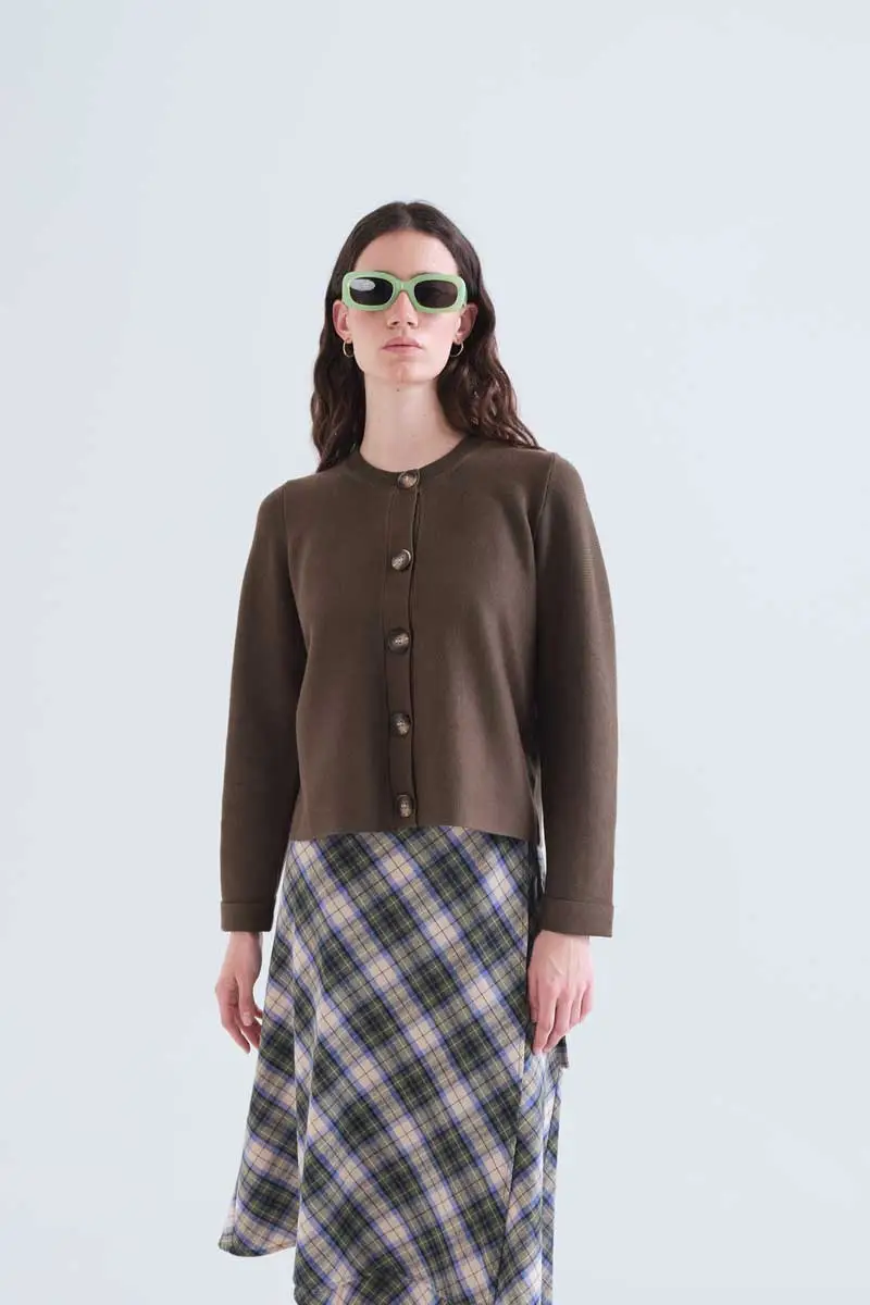 Basic dark green cardigan COMPANIA FANTASTICA Σκούρο πράσινο πλεκτό ζακετάκι. Στρογγυλή λαιμόκοψη και μακριά μανίκια. Κλείσιμο μπροστά με μεγάλα σκούρα μπλε κουμπιά. Λεπτομέρειες σε ριμπ ύφανση. Το μοντέλο έχει ύψος 173 εκ. και φοράει μέγεθος S. 70% Viscose 30% Cotton Πλένεται στο πλυντήριο με κρύο νερό, όχι στεγνωτήριο, στέγνωμα στην σκιά, σιδερώνεται σε μέγιστη θερμοκρασία 110°C Αποστολή σε όλη την Ελλάδα σε 1-3 ημέρες. Διαθέσιμο και στα φυσικά μας κατάστηματα YELLOW BUTTON                                        Χρεμωνίδου & Δαμάρεως 61 Παγκράτι.